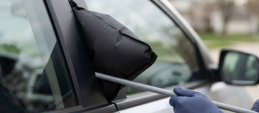 Locksmith using a long-reach tool showing how a locksmith opens a locked car without damaging the door frame