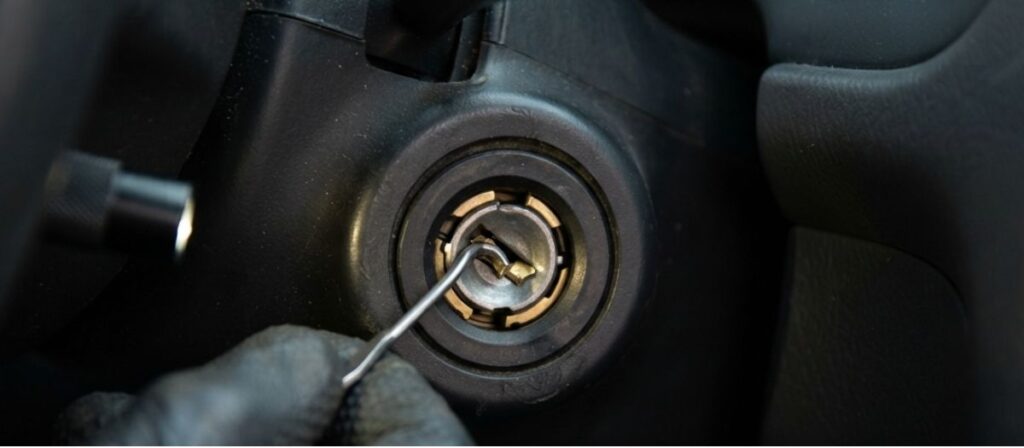 Locksmith performing broken key extraction on a car ignition using a specialized hook tool